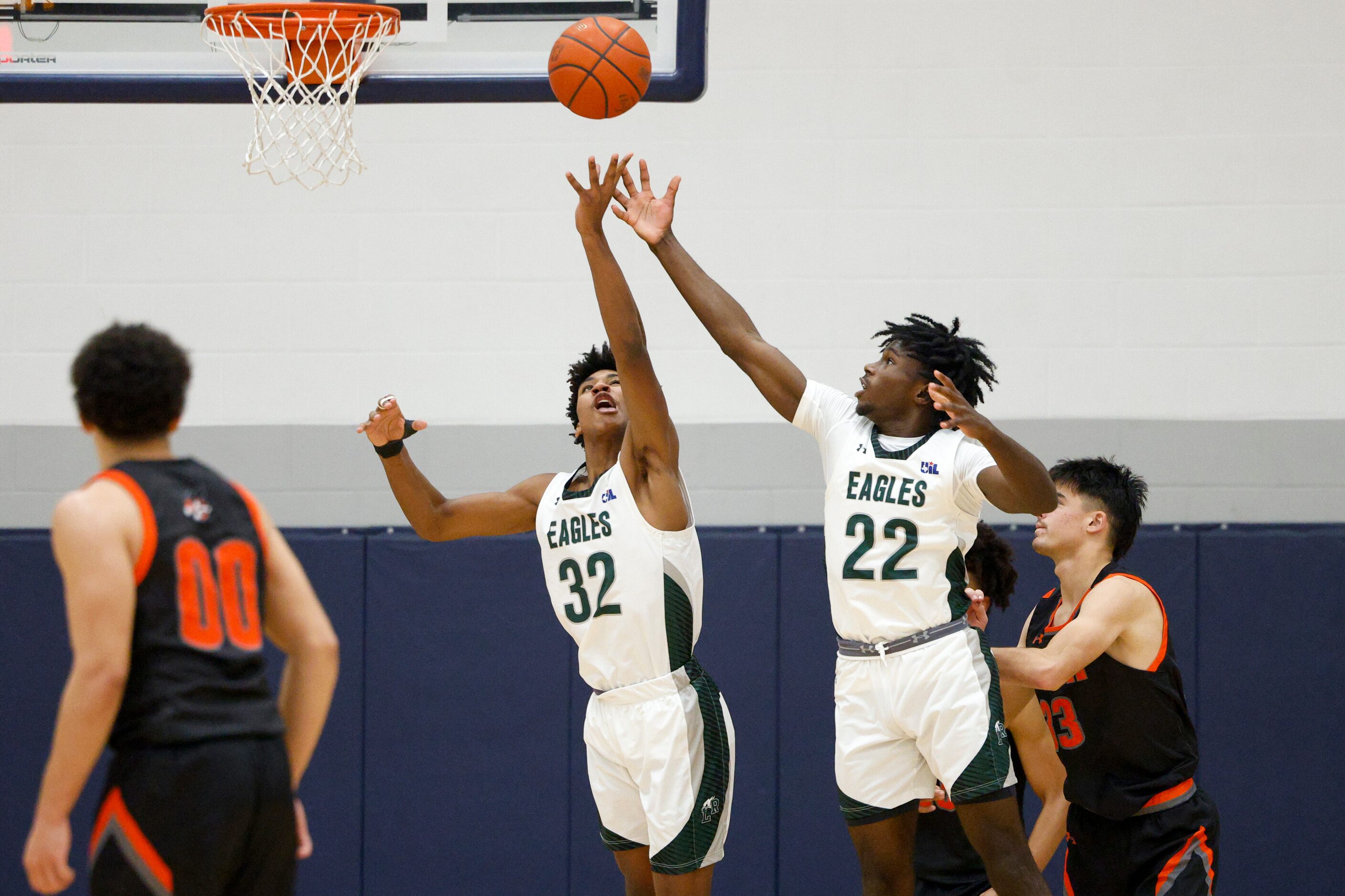 Mansfield Lake Ridge's Shaqir Pack (32) and Matthew Alexander (22) jump to collect a rebound...