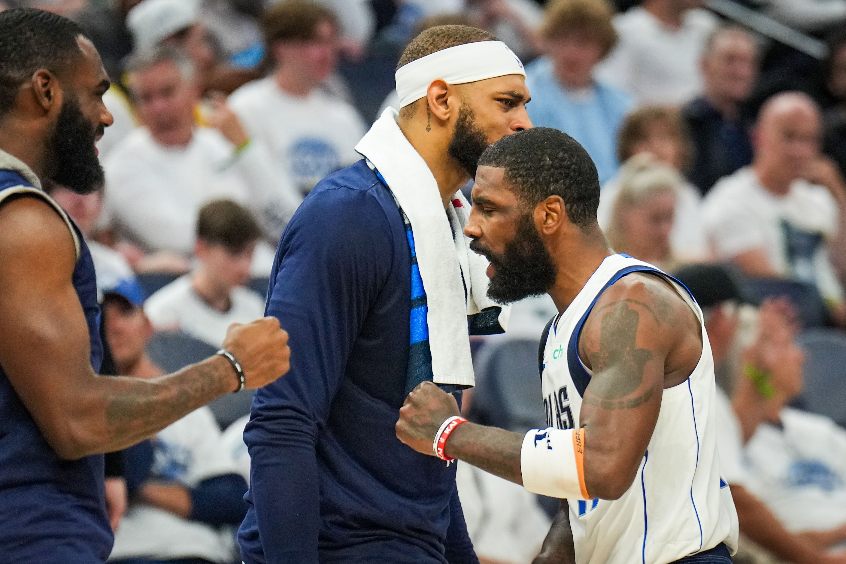 Dallas Mavericks guard Kyrie Irving (11) celebrates with center Daniel Gafford (back) and...