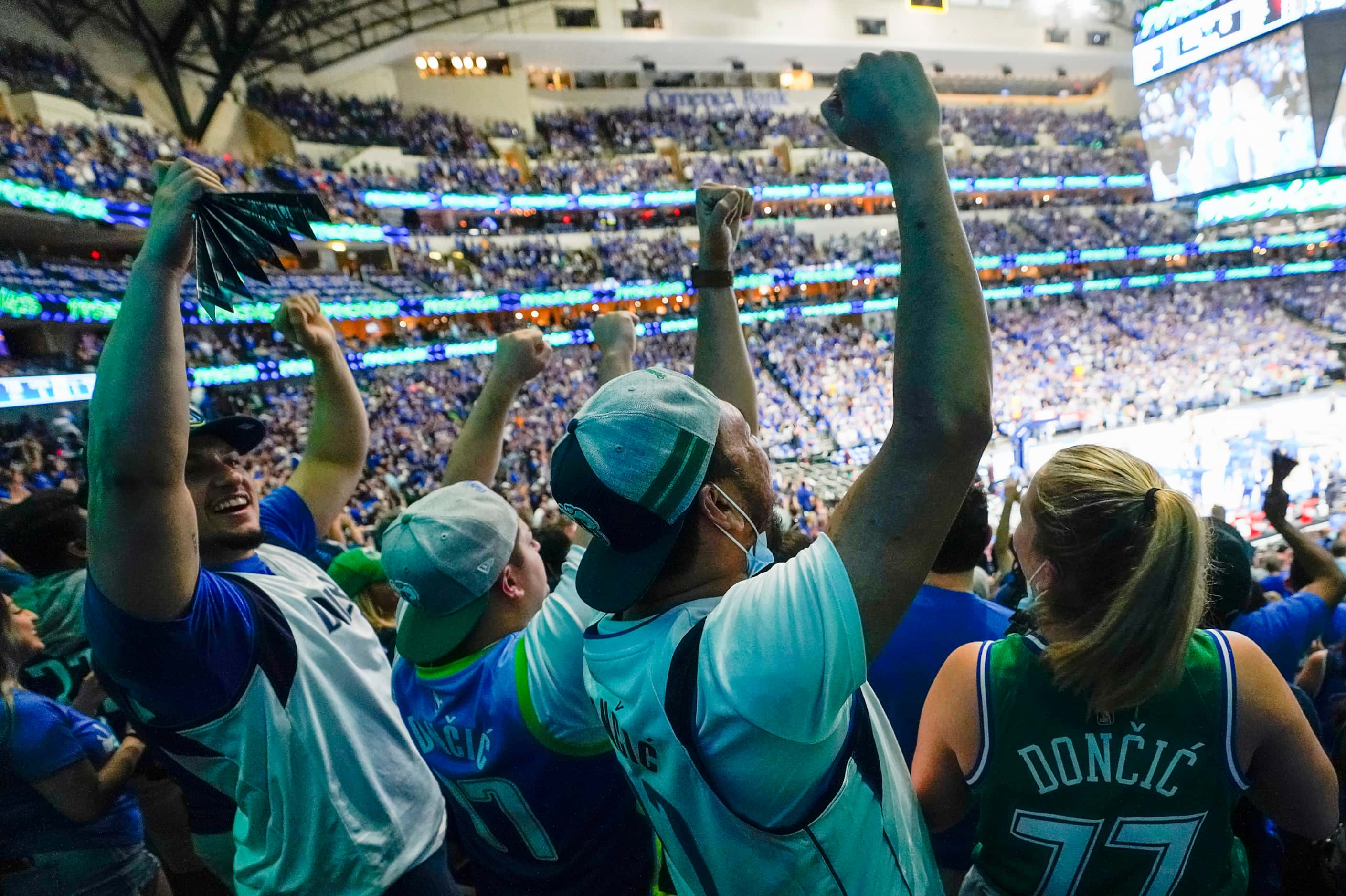 Dallas Mavericks fans celebrate a basket during the fourth quarter of an NBA playoff...