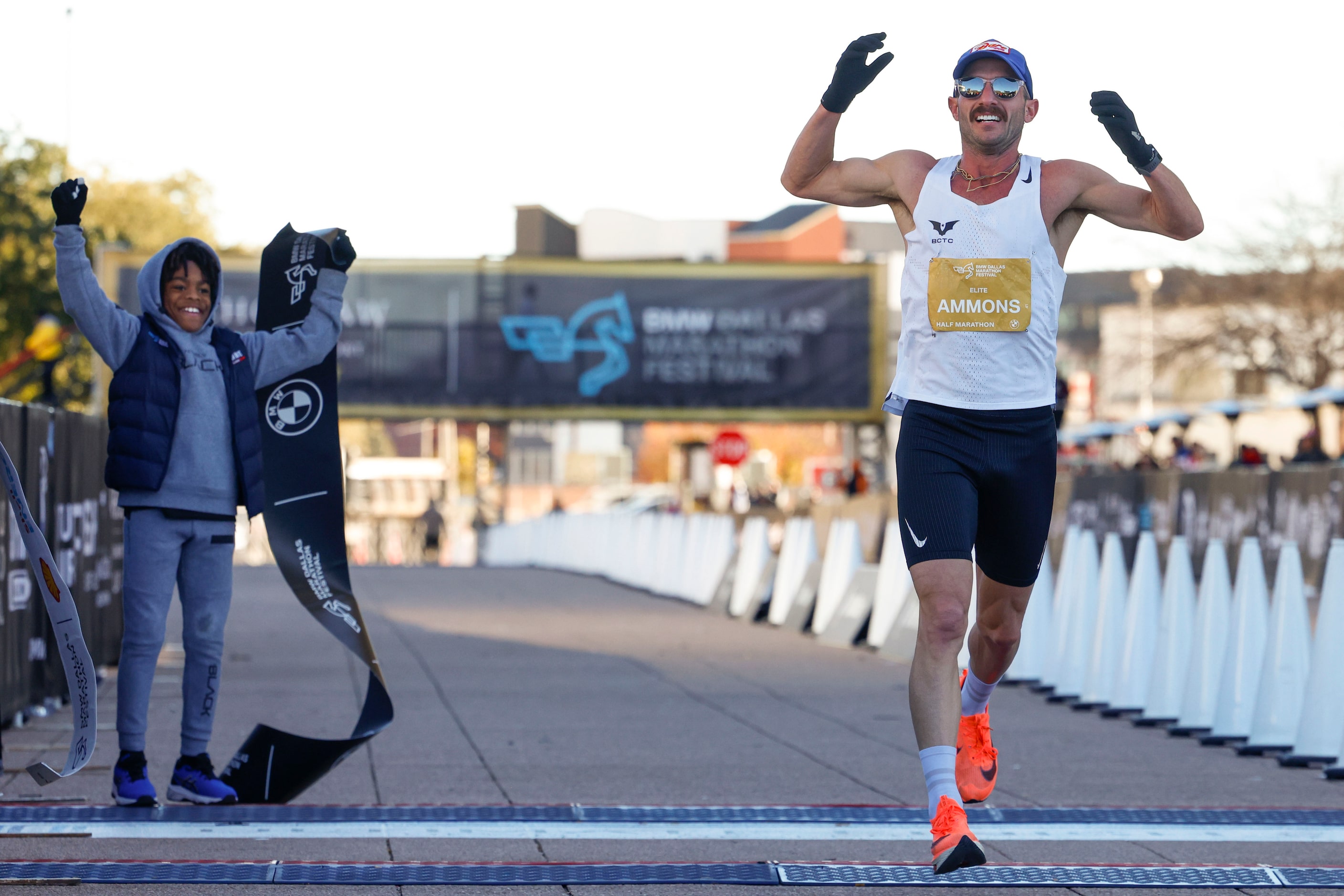 Men’s half marathon finisher Mitch Ammons, 34, of Austin, celebrate as he reaches the finish...