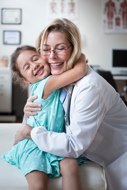 Doctor hugs a child patient in a clinic