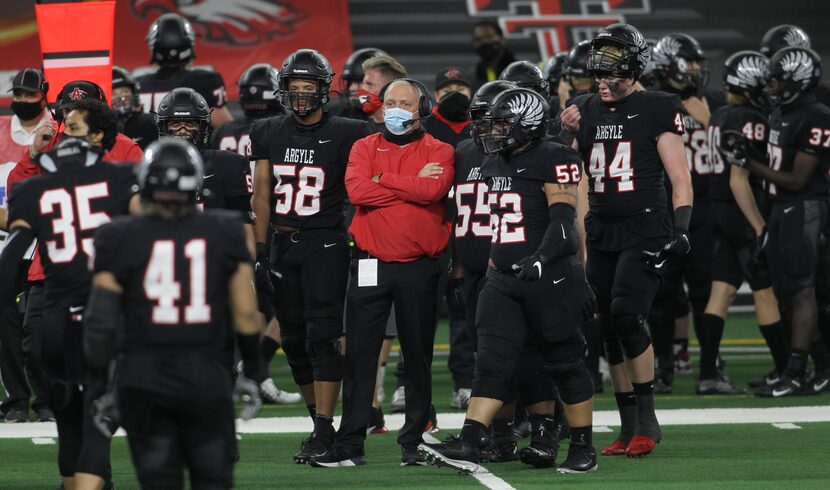 Argyle head coach Todd Rodgers is surrounded by his players as members of the defense come...