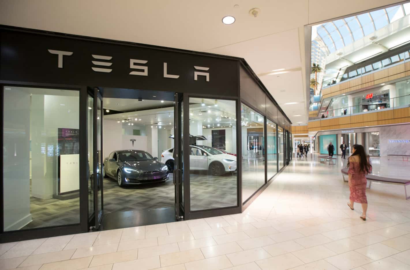 A woman walks past the Tesla showroom inside Galleria Dallas in Dallas on Monday, January...