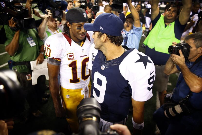 Dallas Cowboys quarterback Tony Romo (9) and Washington Redskins quarterback Robert Griffin...