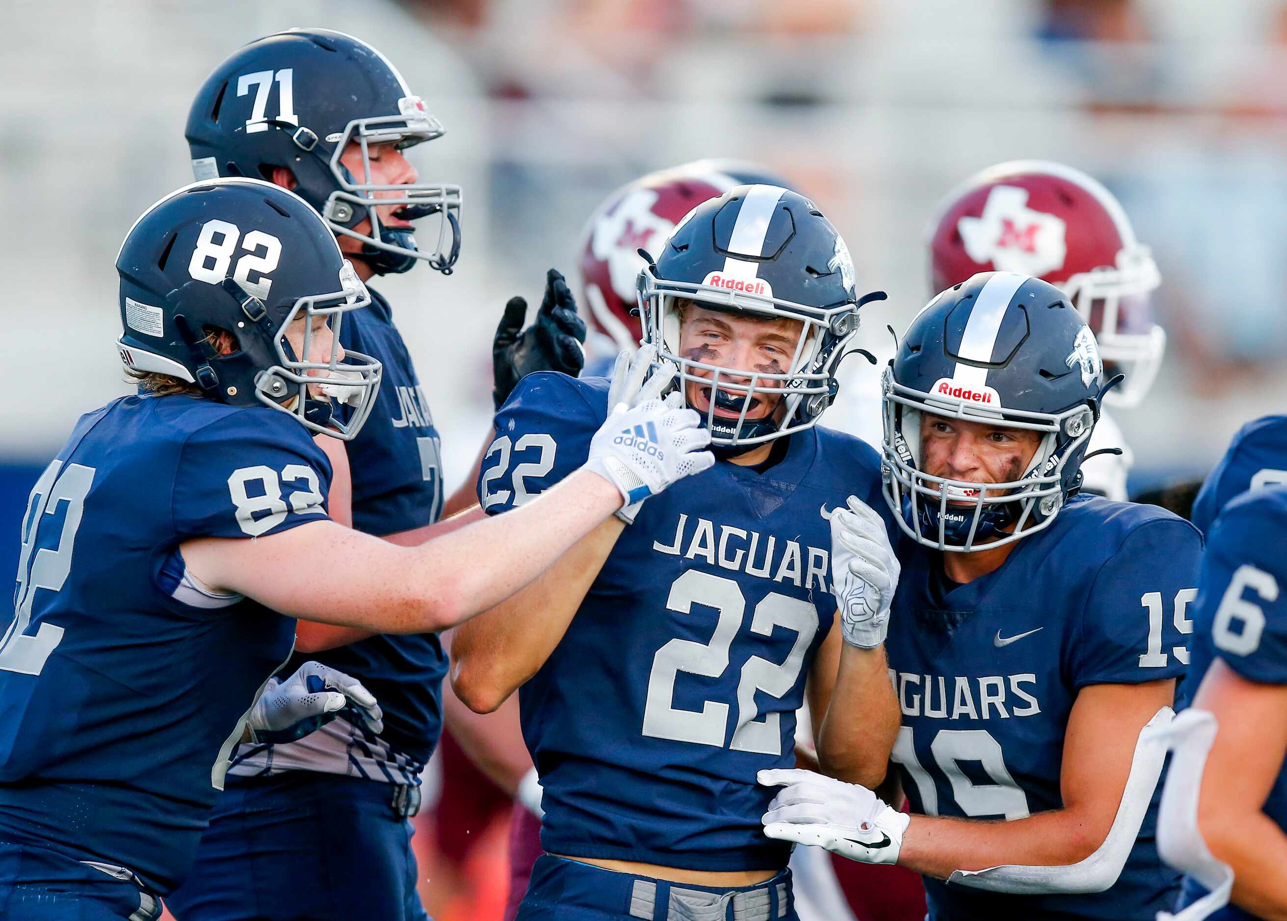 Flower Mound senior running back Cole Smith (22) is congratulated by teammates after scoring...