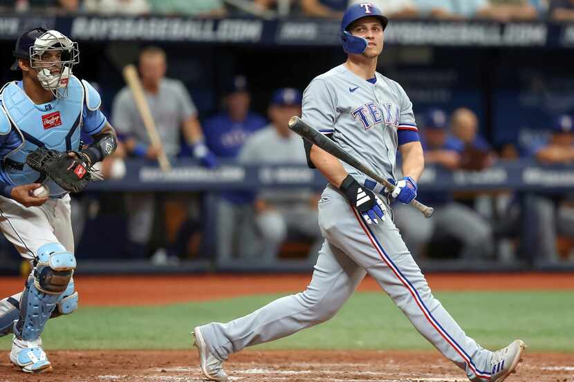 Texas Rangers' Corey Seager, right, reacts to striking out in front of Tampa Bay Rays...