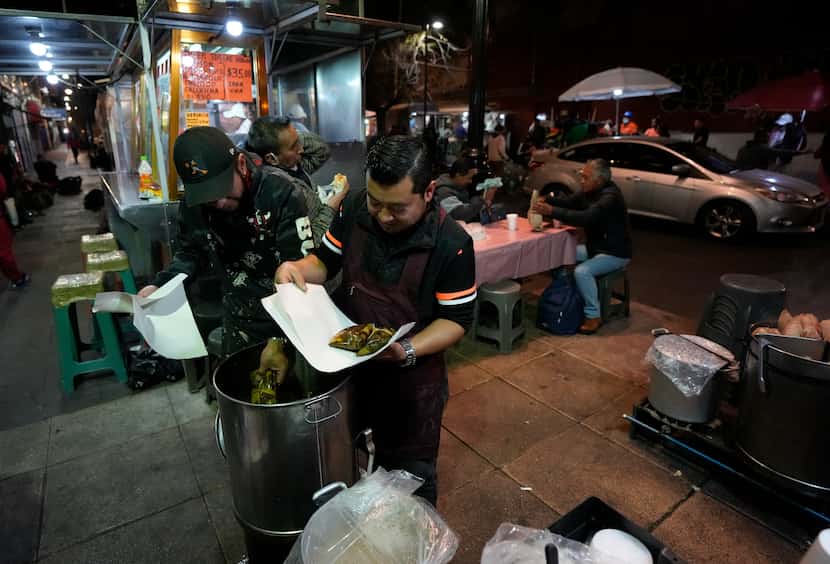 Vendedores callejeros venden tamales de estilo oaxaqueño en una calle en el centro de la...