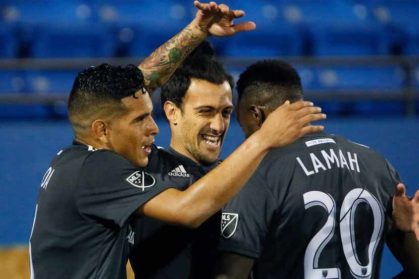 FC Dallas forward Maximiliano Urruti (37) is congratulated by midfielder Victor Ulloa, left,...