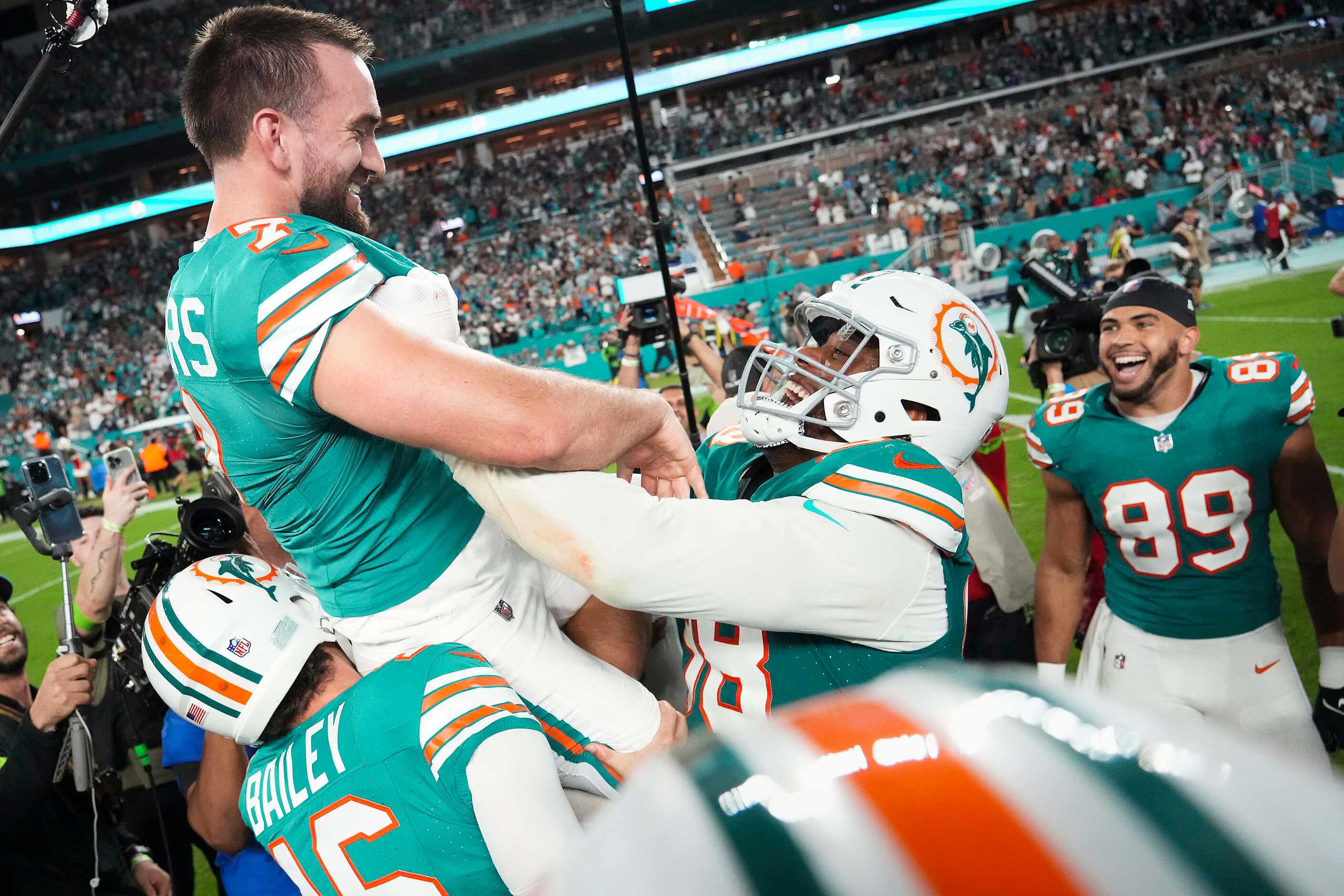 Miami Dolphins place kicker Jason Sanders (7) celebrates with Raekwon Davis (98) and Jake...