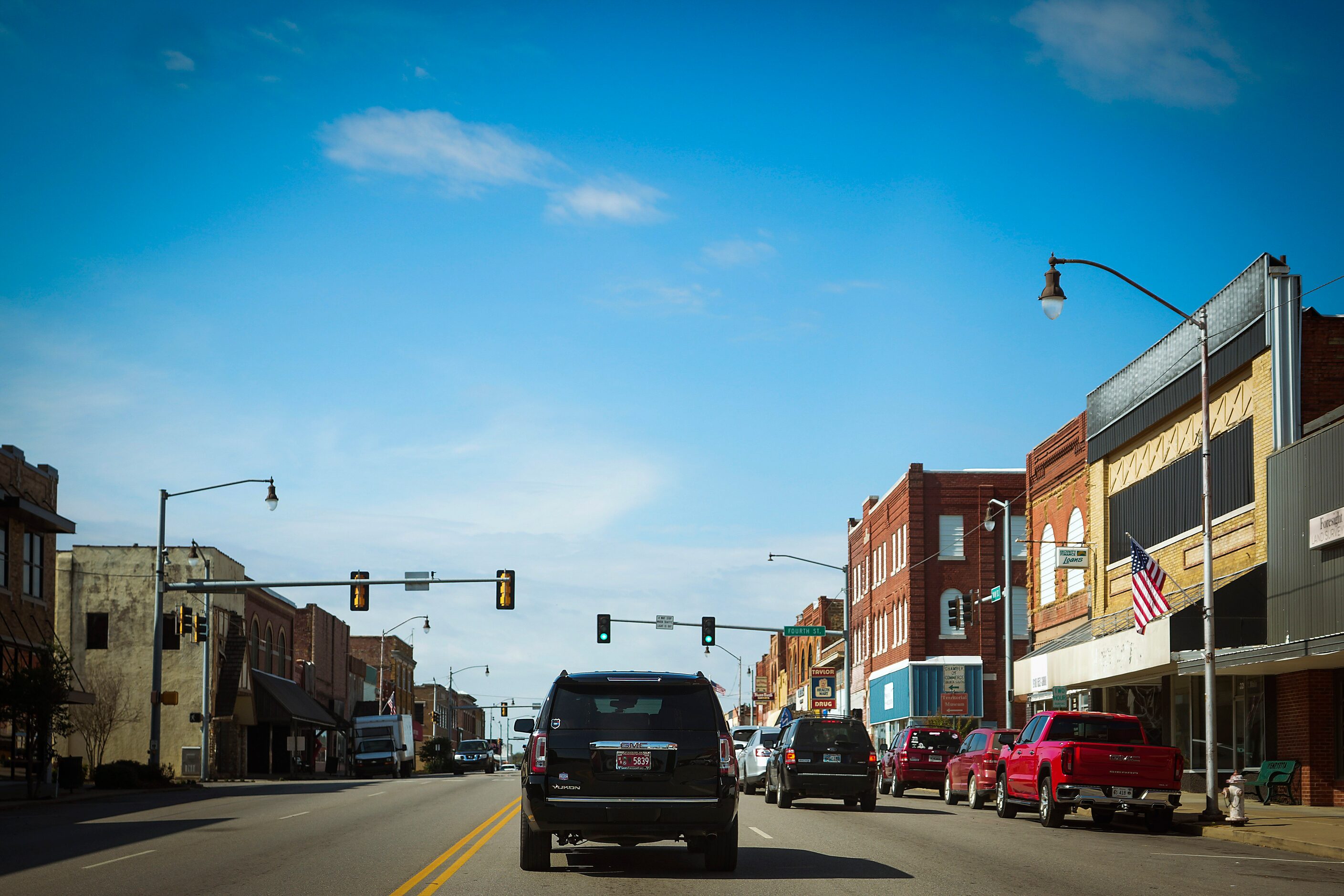 An SUV drives down Henryetta's Main Street carrying Troy Aikman to surprise students during...