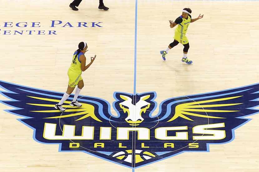 Dallas Wings players cross midcourt during their first home opener against the San Antonio...