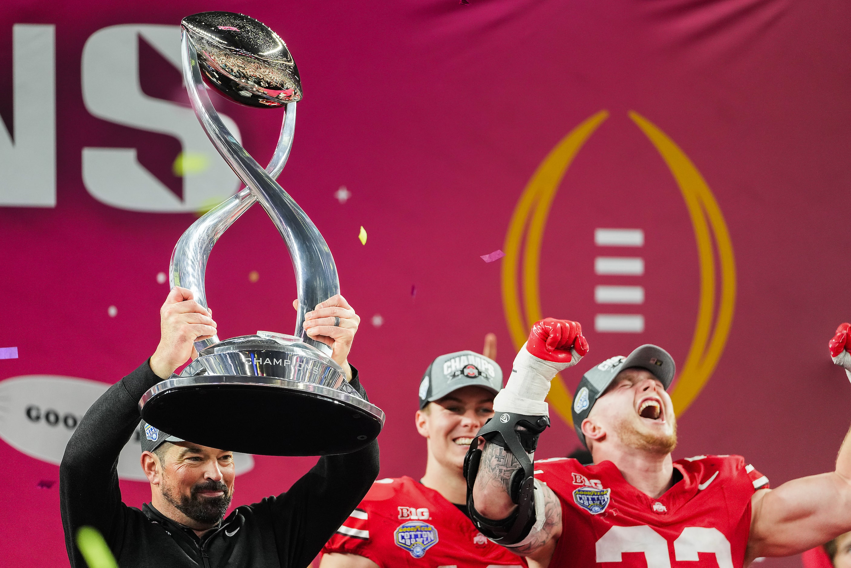 Ohio State head coach Ryan Day lifts the trophy as he celebrates with quarterback Will...