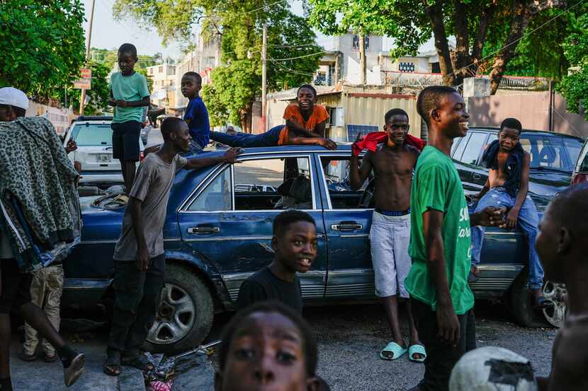 Youths hang out near cars serving as street barricades placed there by residents to deter...