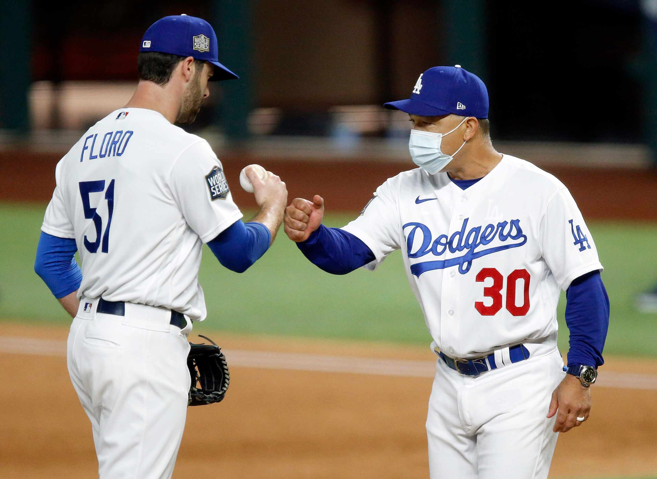 Los Angeles Dodgers manager Dave Roberts gives relief pitcher Dylan Floro (51) a fist bump...