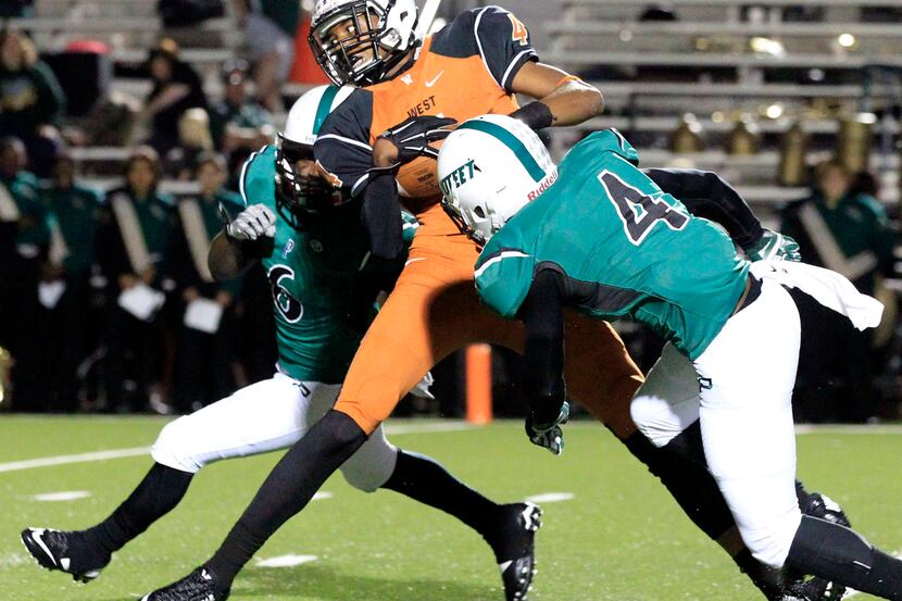 (TXHSFB) West Mesquite's Dee Anderson (4) takes his reception between Mesquite Poteet...