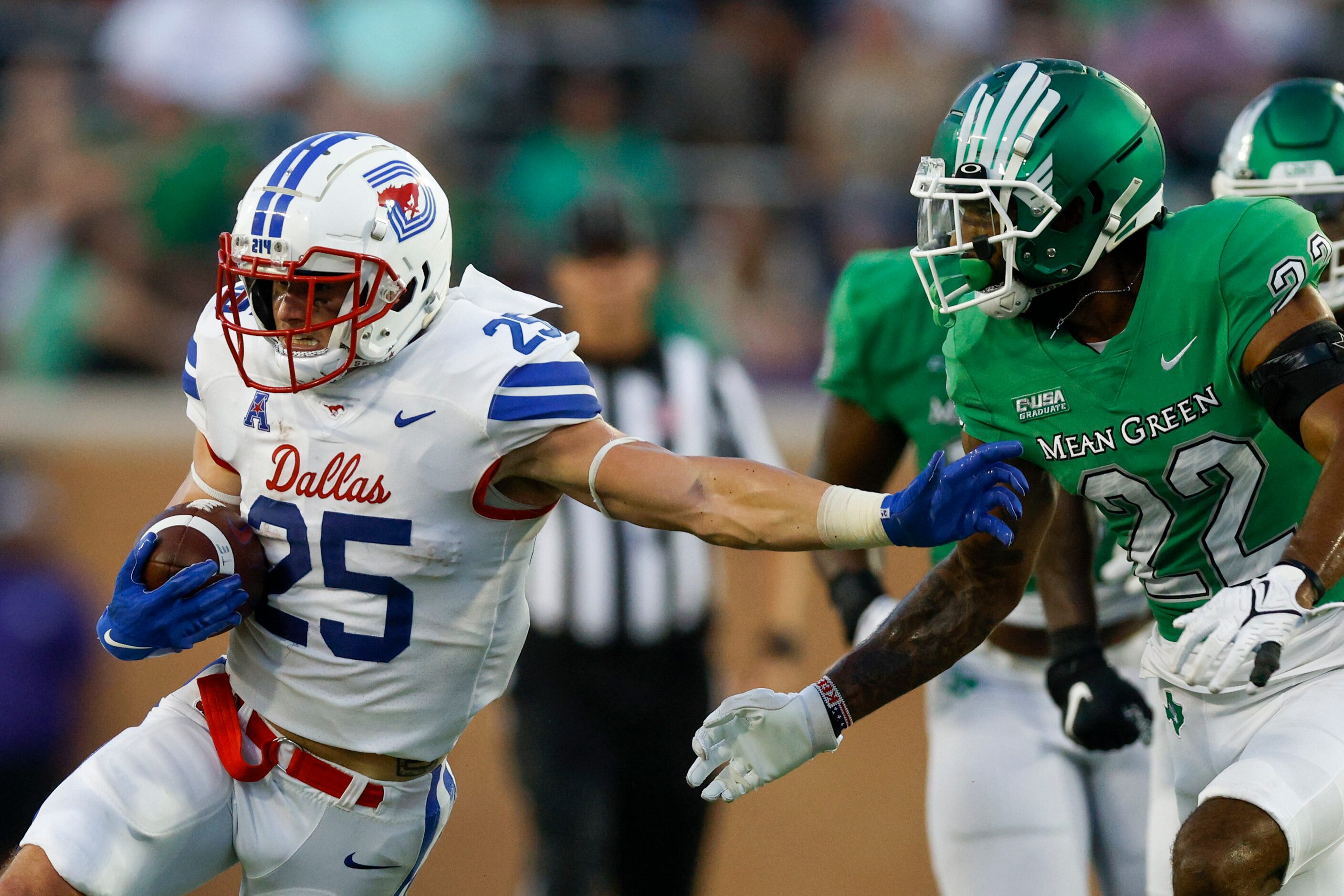 SMU running back TJ McDaniel (25) stiff-arms UNT defensive back Keelan Crosby (22) during...