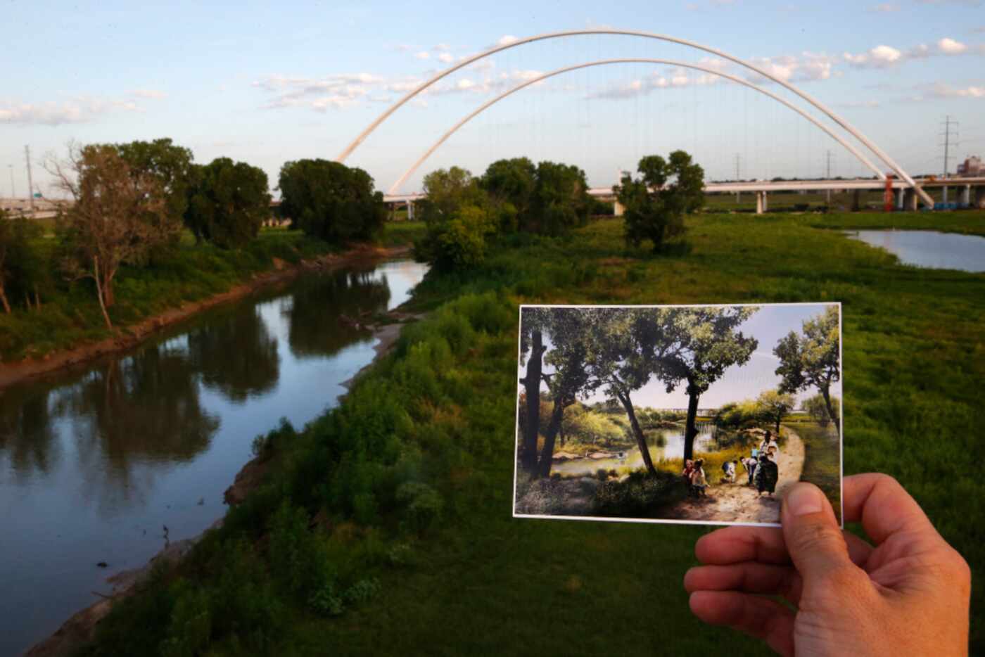  A photograph of the proposed Trinity River park area is held in front of the Interstate 30...
