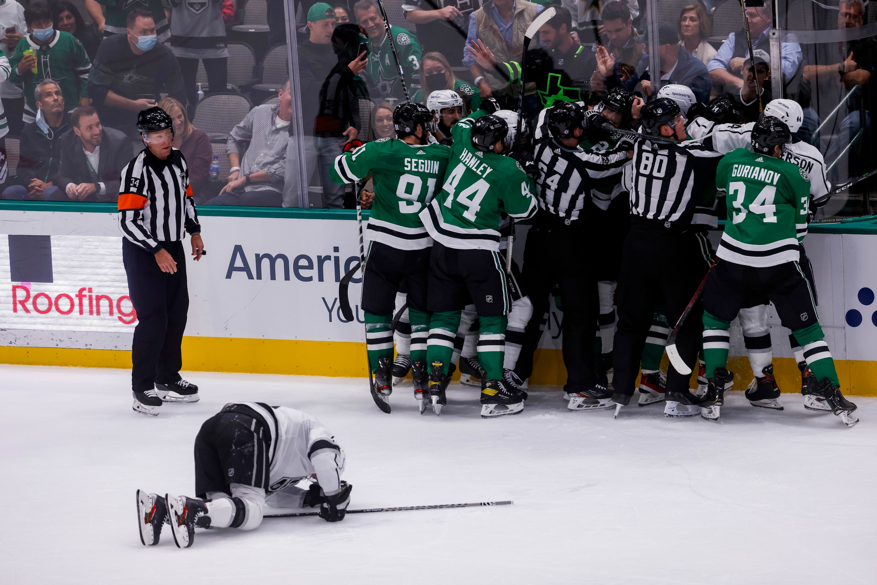 Referees pull players from a fight during the second period of a Dallas Stars home opener...