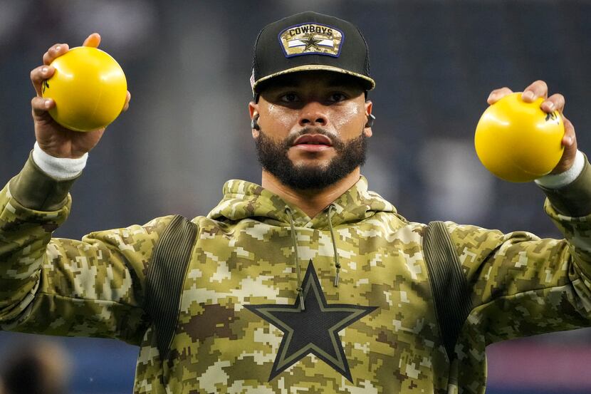 Dallas Cowboys quarterback Dak Prescott stretches before an NFL football game against the...