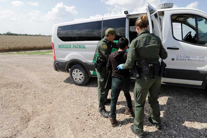  In this June 25, 2018 file photo, U.S. Border Patrol agents load a migrant from Guatemala...