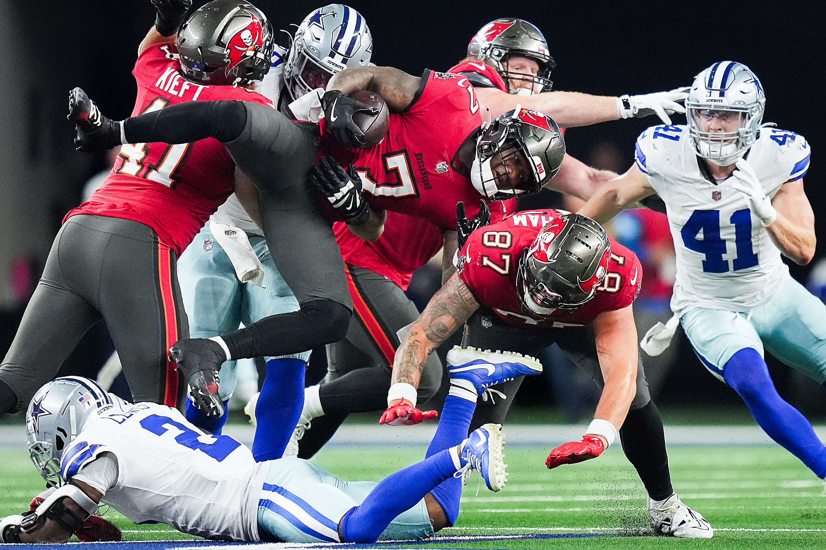 Tampa Bay Buccaneers running back Bucky Irving (7) is tripped up by Dallas Cowboys...