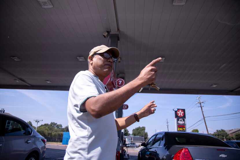 Store manager Abdullah Mahmood  points at a bullet hole on the roof of the Texaco he manages...