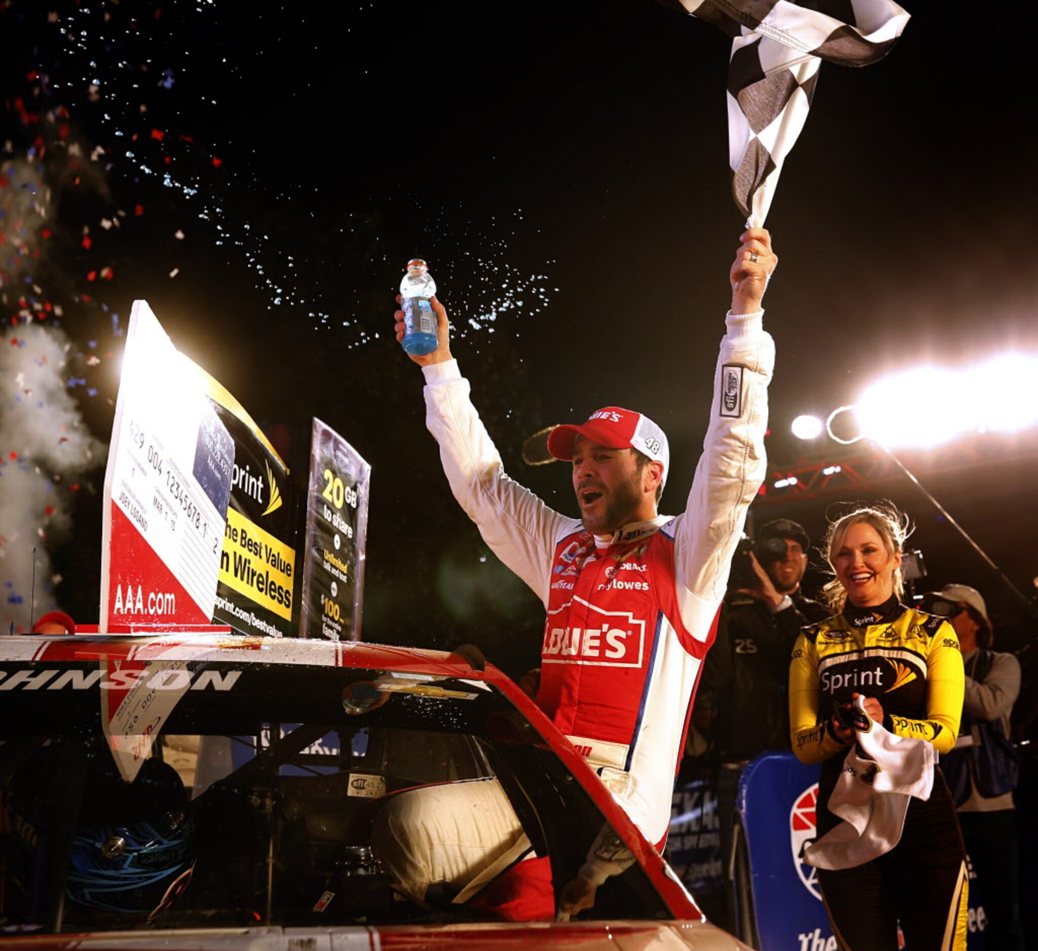 Sprint Cup Series driver Jimmie Johnson (48) crawls from his car and celebrates his AAA...