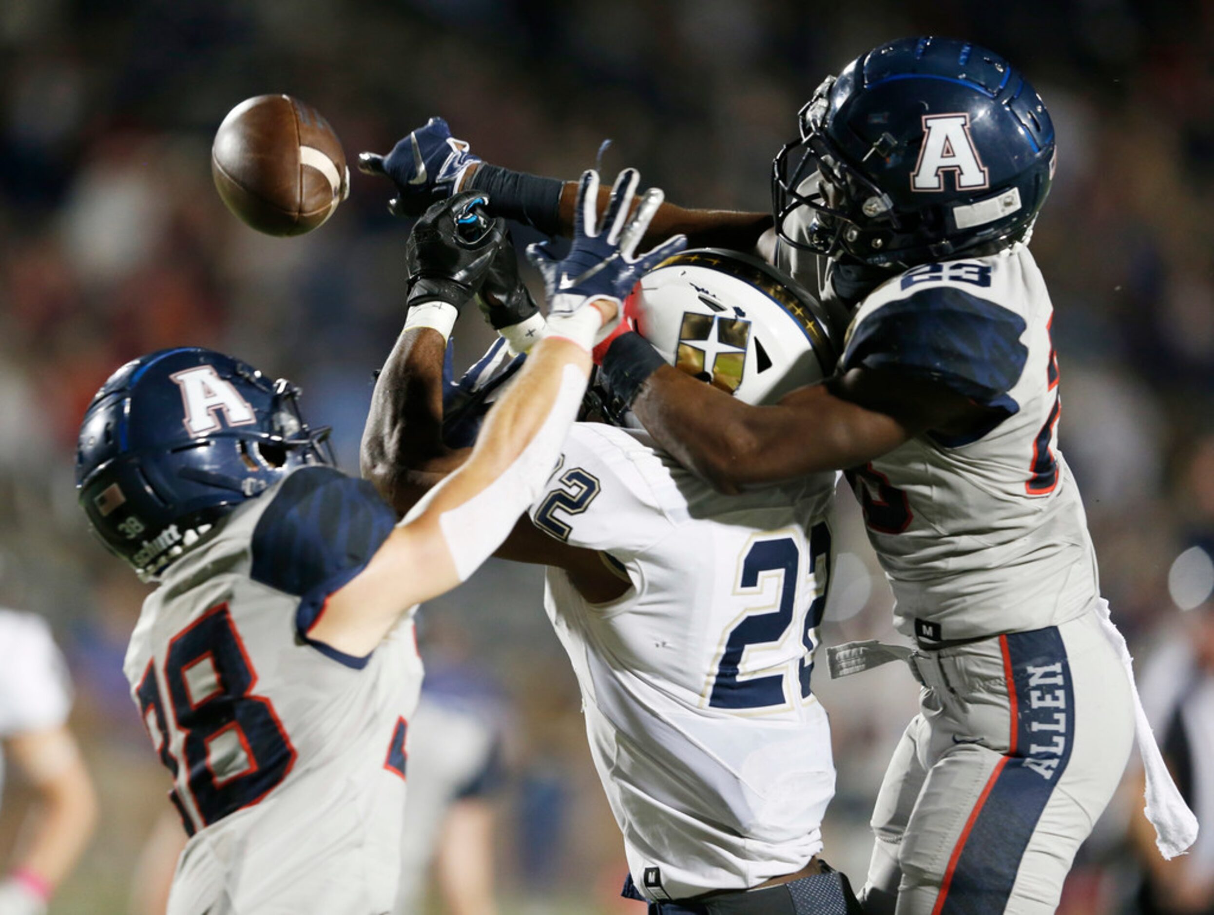 Allen's Zayteak McGhee (23) and Will Drogosch (38) break up a pass intended for Jesuit's EJ...