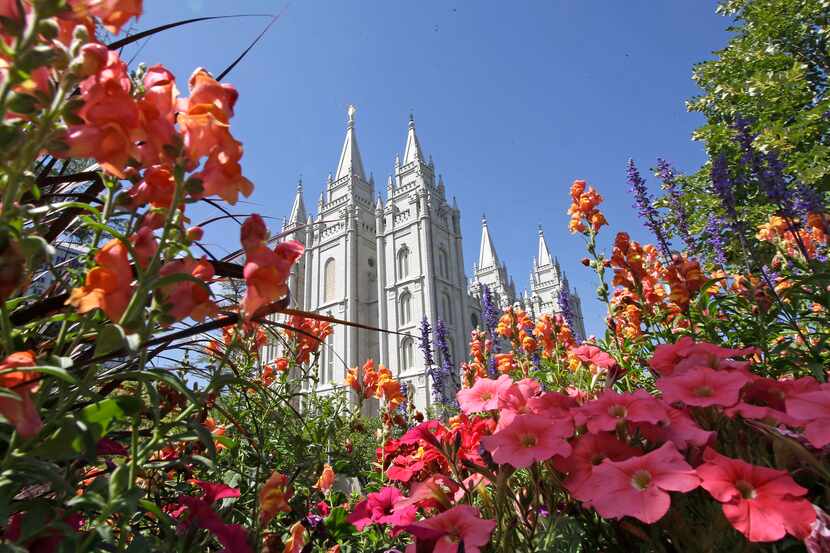 FILE - Flowers bloom in front of the Salt Lake Temple, at Temple Square, on Aug. 4, 2015, in...
