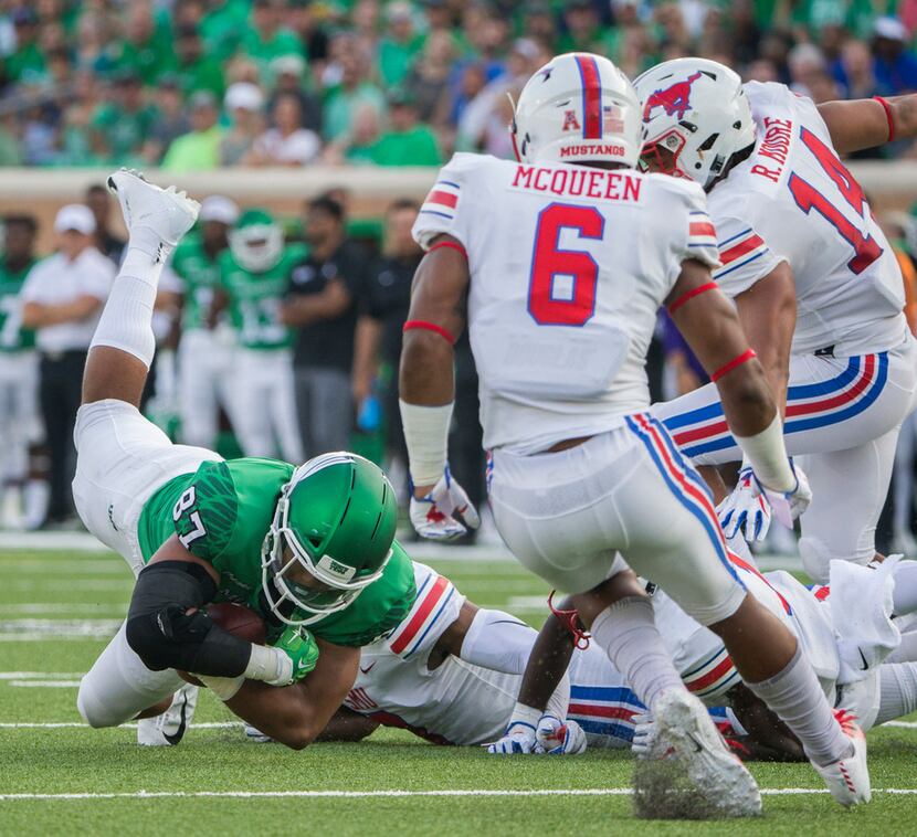 North Texas Mean Green tight end Kelvin Smith (87) is brought down by Southern Methodist...
