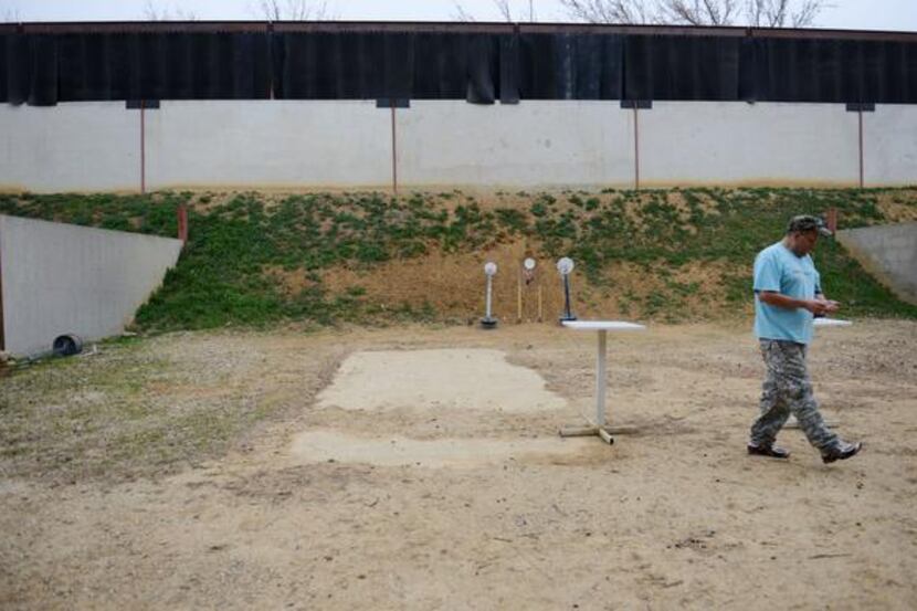 
Dallas Pistol Club member Javier Criado shoots a round at the club's private outdoor range...