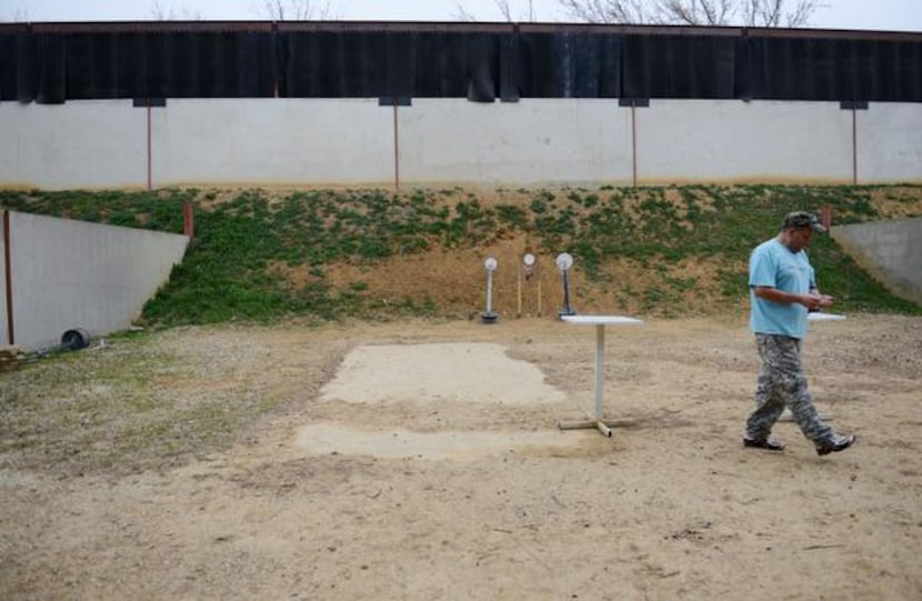 
Dallas Pistol Club member Javier Criado shoots a round at the club's private outdoor range...