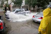 A pickup drives through flooding close to the intersection of N Fitzhugh Ave and Fuqua St on...