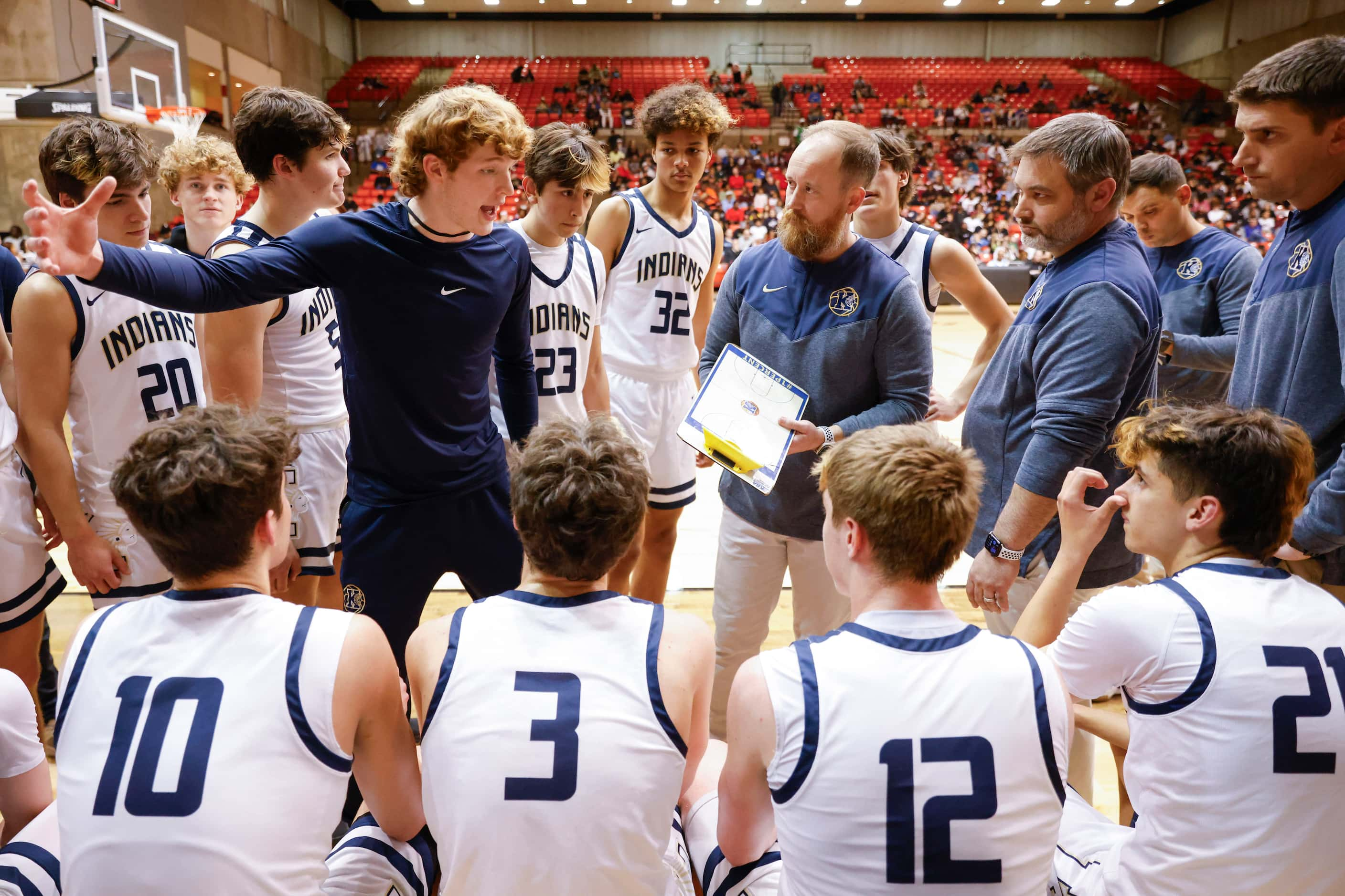 Keller High boys basketball head coach Zachary Weir (center right) listens as he addresses...