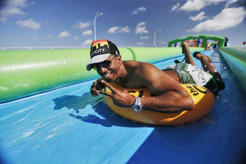 Marquess Jones slid down a water slide during the Slide the City event in the 3400 block of...