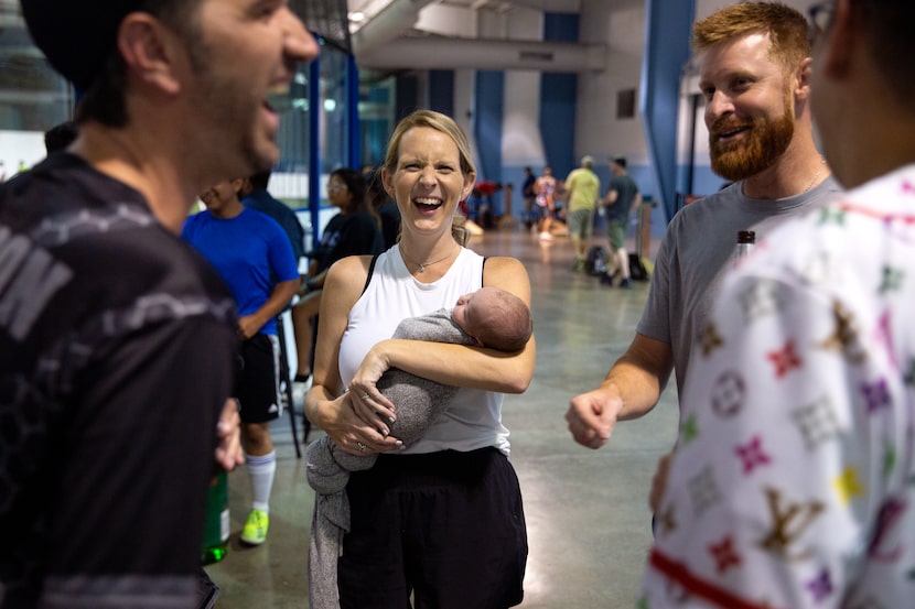 Lynsey Belloso, centered, laughs with fellow cornhole competitors as she carries her...