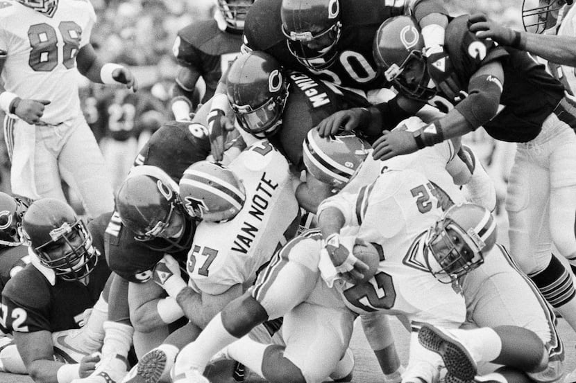 In this Nov. 24, 1985, file photo, Atlanta Falcons' Gerald Riggs (42) gets a dose of heavy...