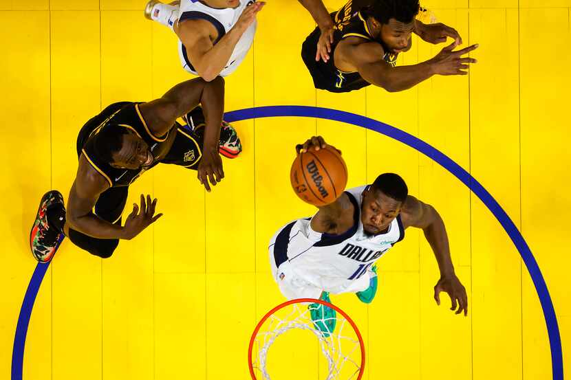 Dallas Mavericks forward Dorian Finney-Smith (10) goes up for a dunk past Golden State...