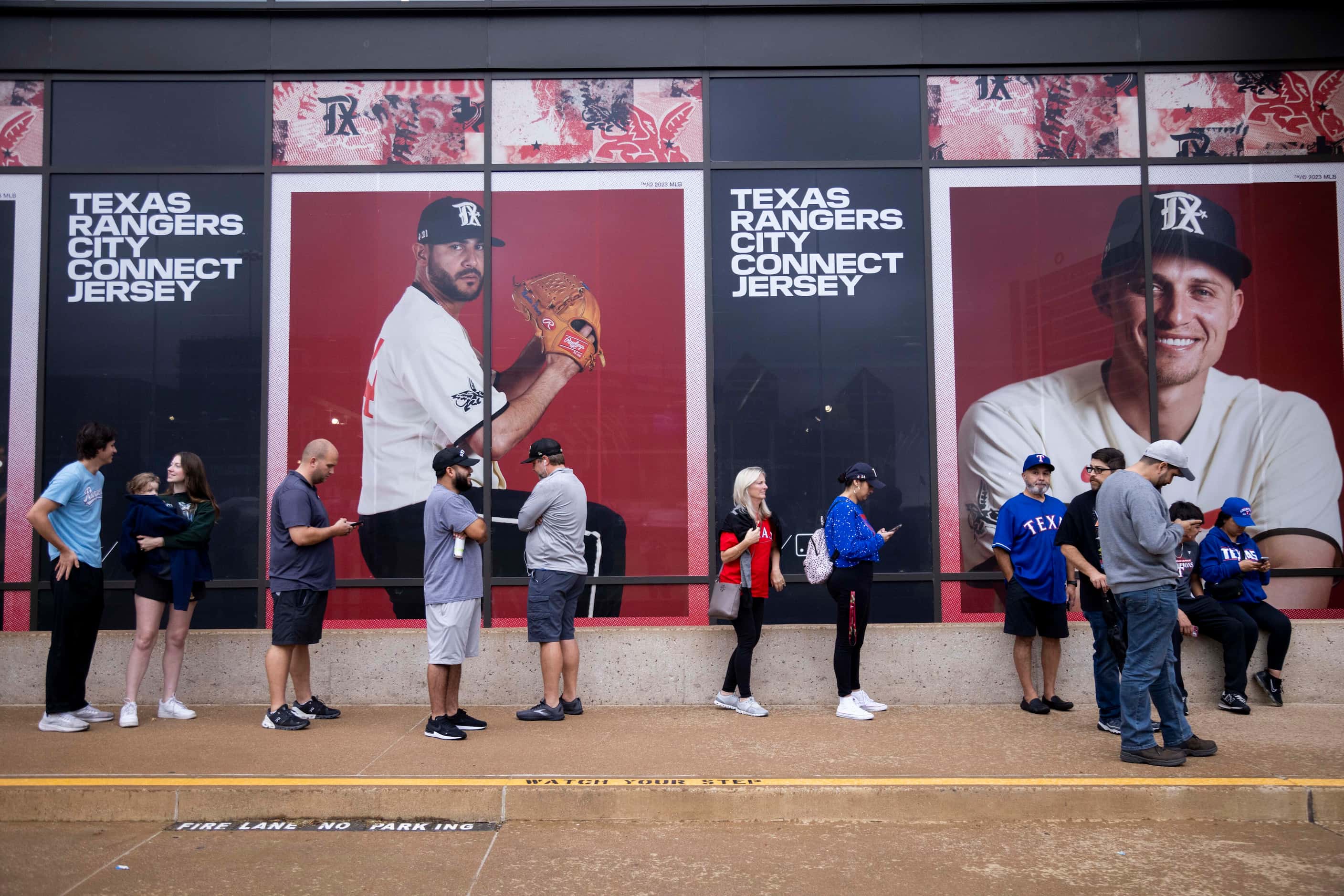 Fans wait for the Grand Slam Team Store at Globe Life Field to open in Arlington on Tuesday,...
