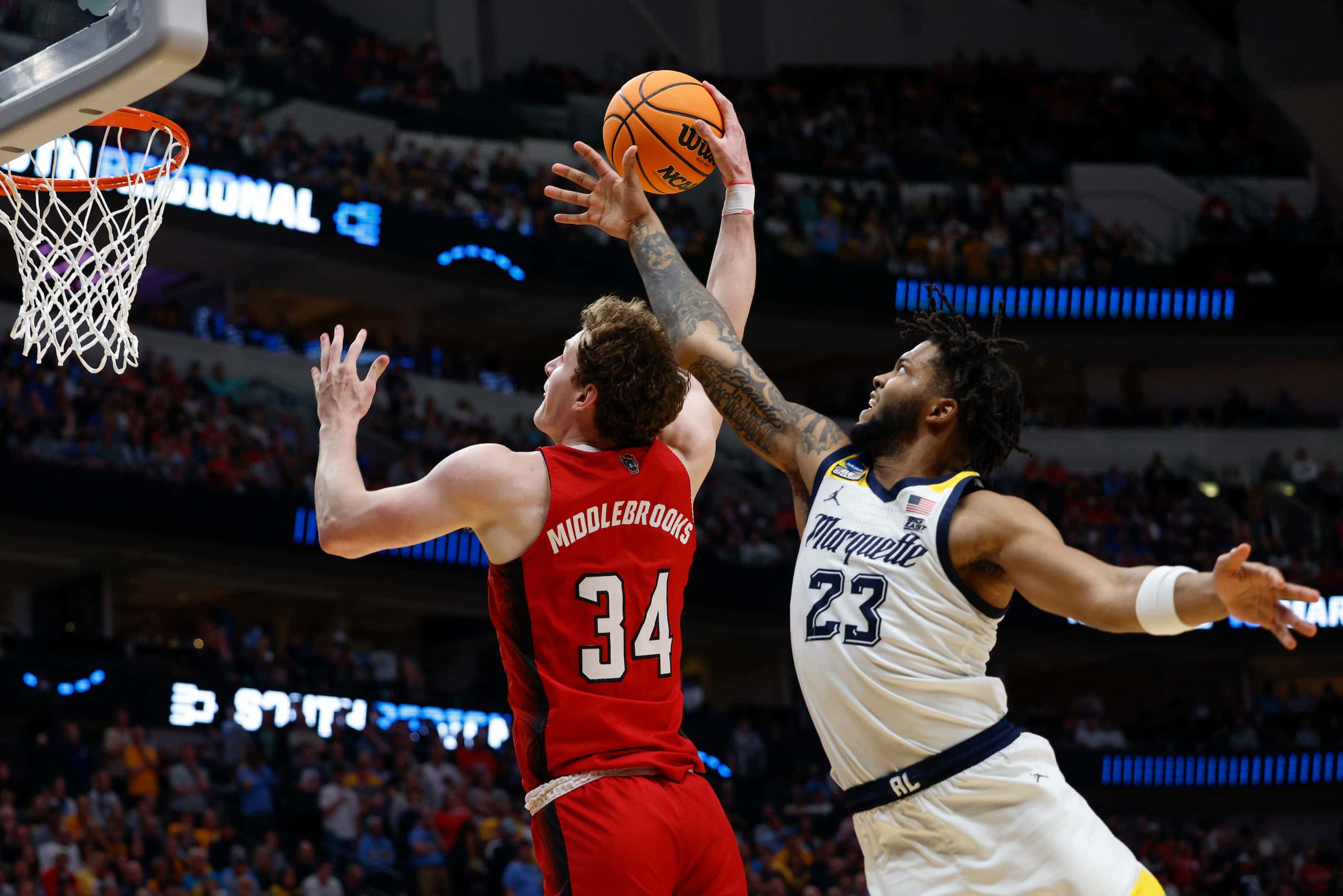 North Carolina State forward Ben Middlebrooks (34) dunks the ball ahead of Marquette forward...