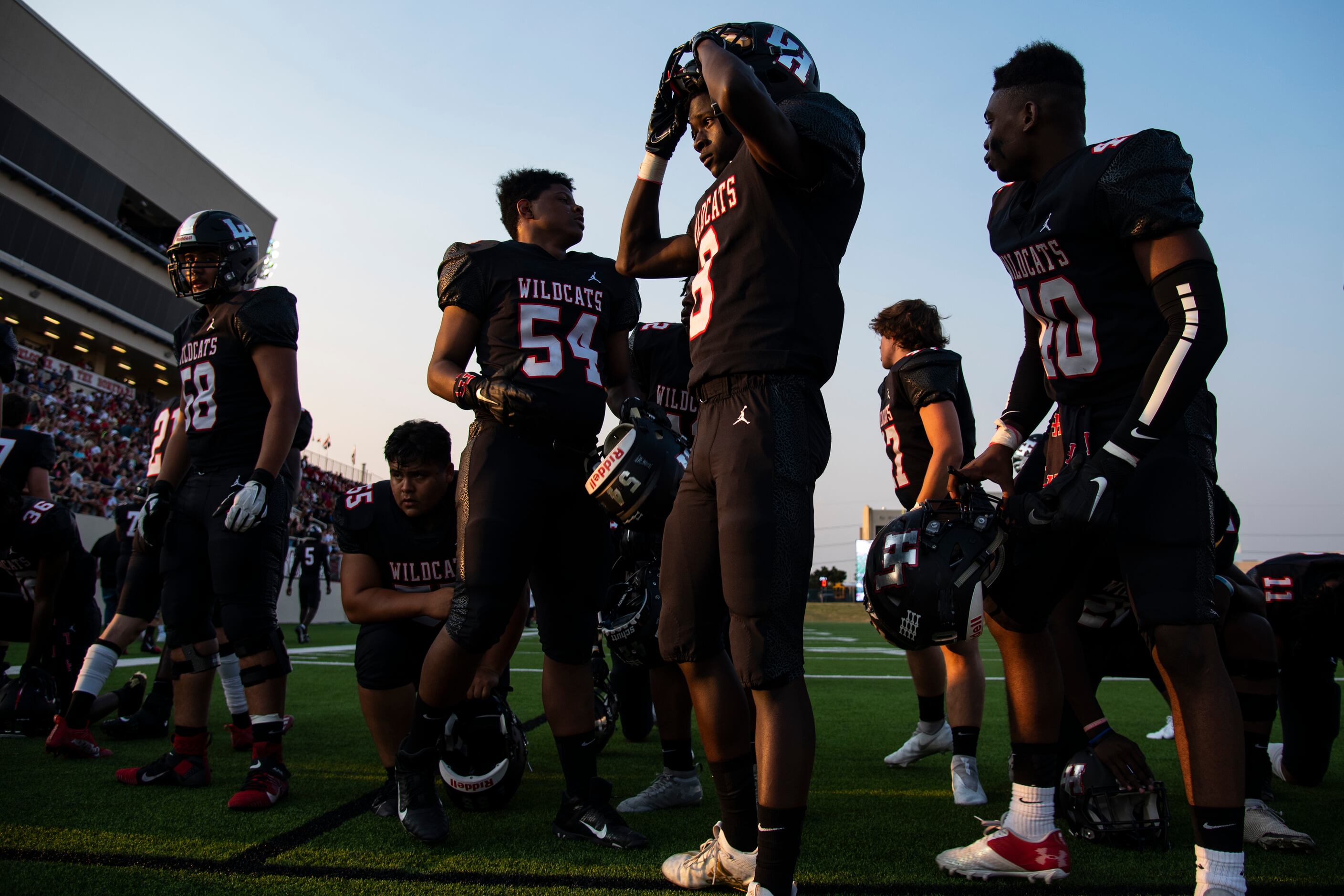 Lake Highlands sophomore Miron Magee (8) puts on his helmet after saying a prayer prior to...