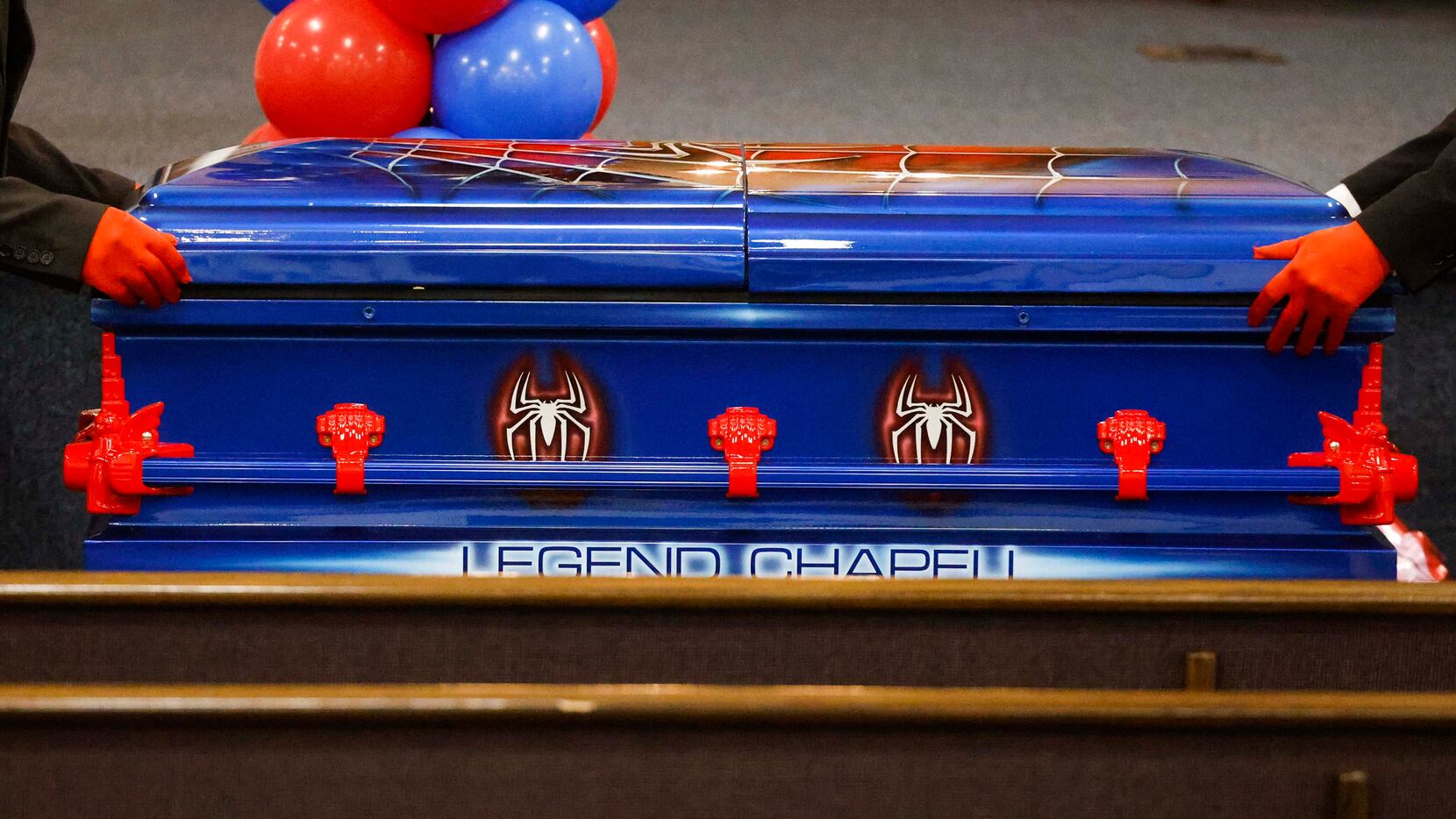 Pallbearers move the Spider-man themed casket of 6-year-old Legend Chappell after a funeral...