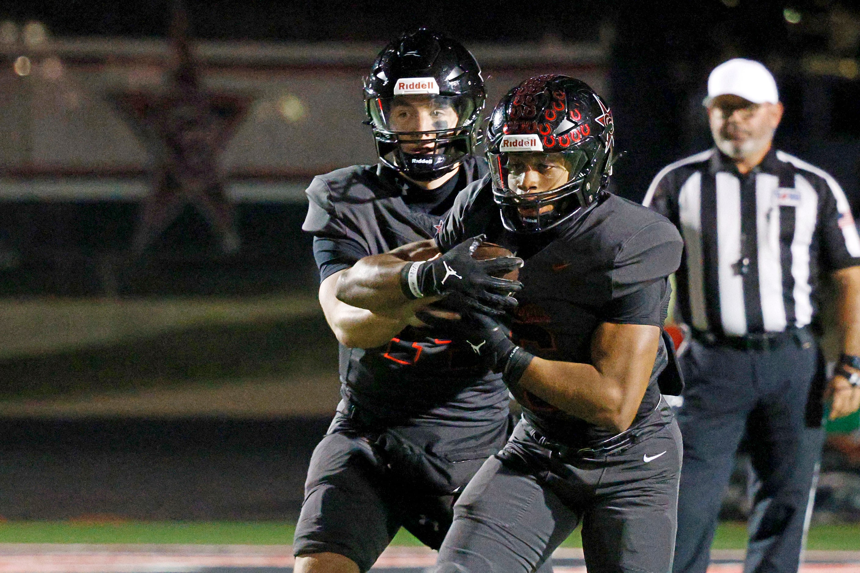 Coppell's quarterback Edward Griffin (14) hands off to Coppell's O'Marion Mbakwe (6) in the...