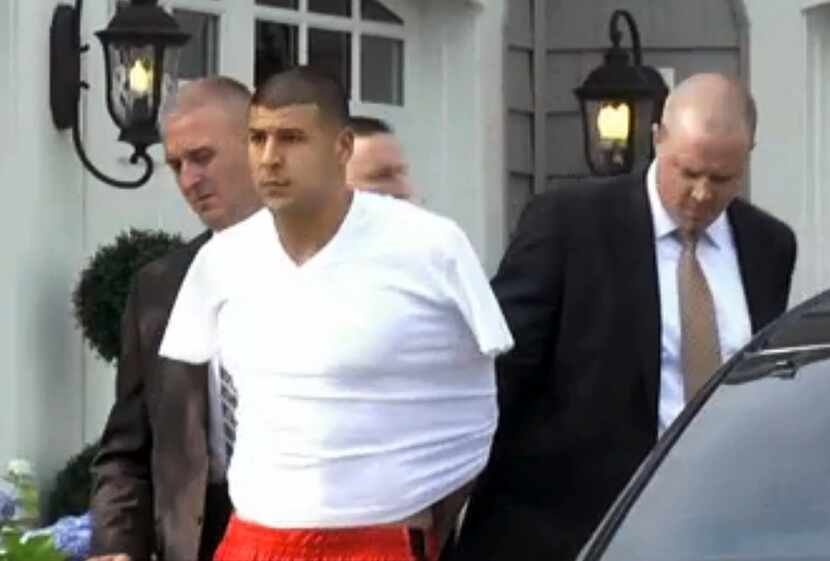 In this image taken from video, police escort Aaron Hernandez from his home in handcuffs in...