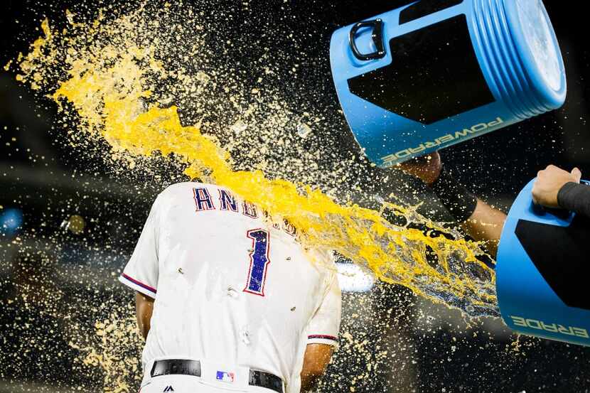 Texas Rangers shortstop Elvis Andrus is doused with sports drink after a victory over the...