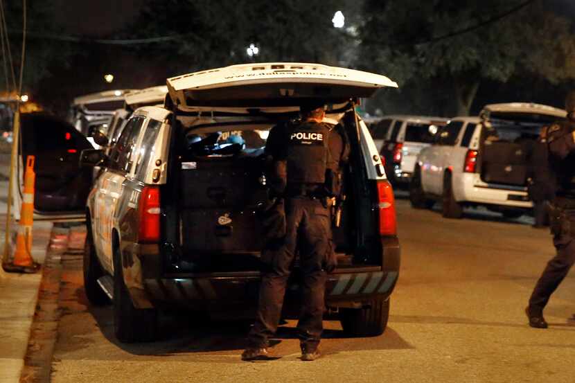 Dallas SWAT officers return to their vehicles after an hours long incident in which they...