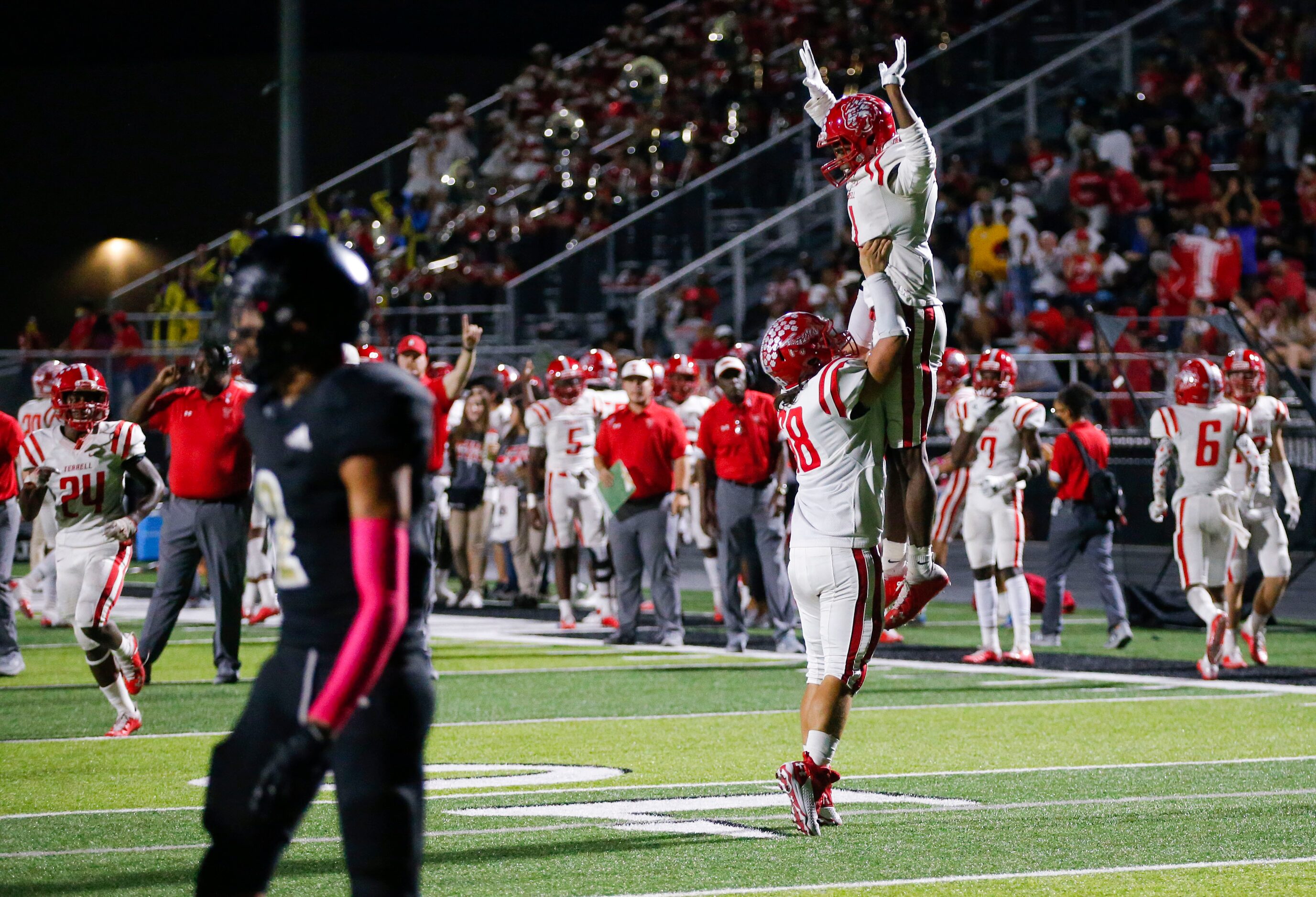 Terrell junior Kanye Nix is lifted into the air in celebration by senior San Lukus Coronado...