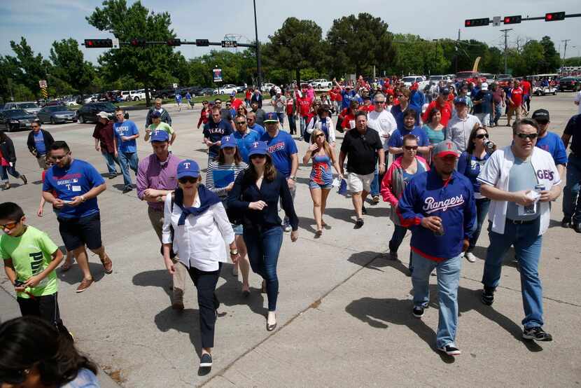 Fans cross Ballpark Park to enter the stadium before the home opening day game for the Texas...