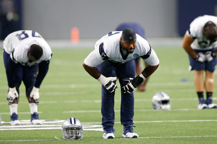 Dallas Cowboys tackle Tyron Smith (77) stretches at the end of practice during training camp...