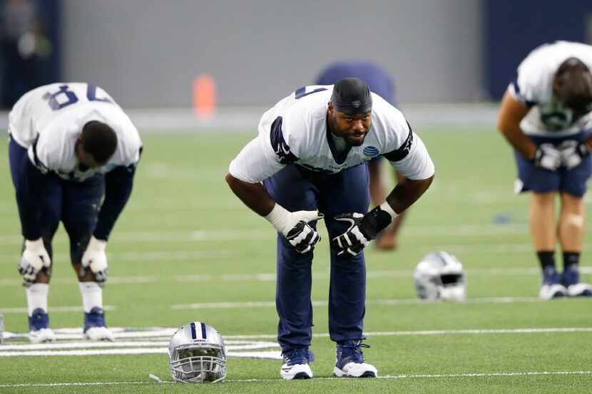 Dallas Cowboys tackle Tyron Smith (77) stretches at the end of practice during training camp...